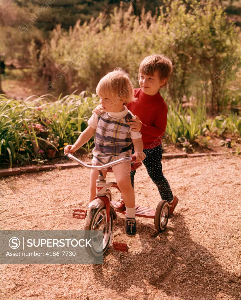 1960S 1970S Young Boy And Girl Playing Together Riding Tricycle
