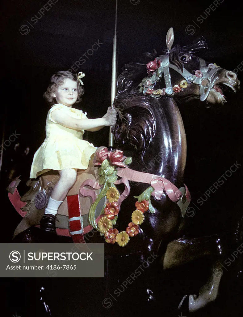 1940S 1950S Little In Yellow Dress Girl Riding Carousel Horse On Merry-Go-Round