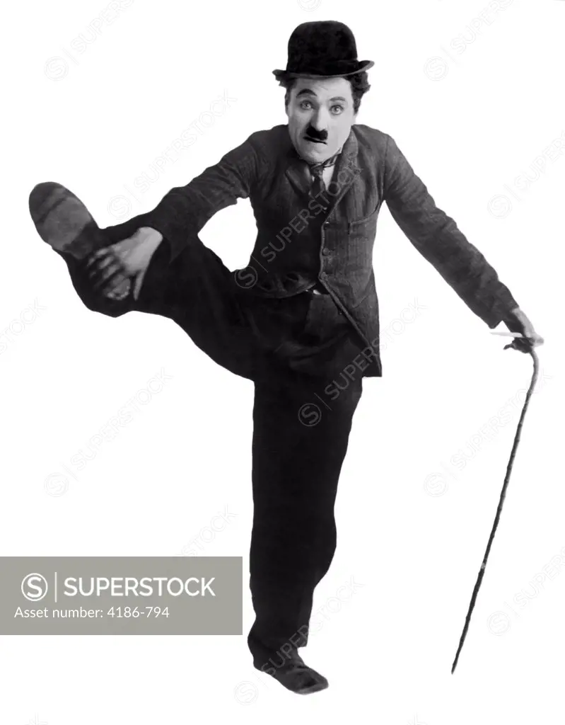 1910S Circa 1915 Charles Chaplin As The Little Tramp Standing On One Leg Holding Other Up With Hand