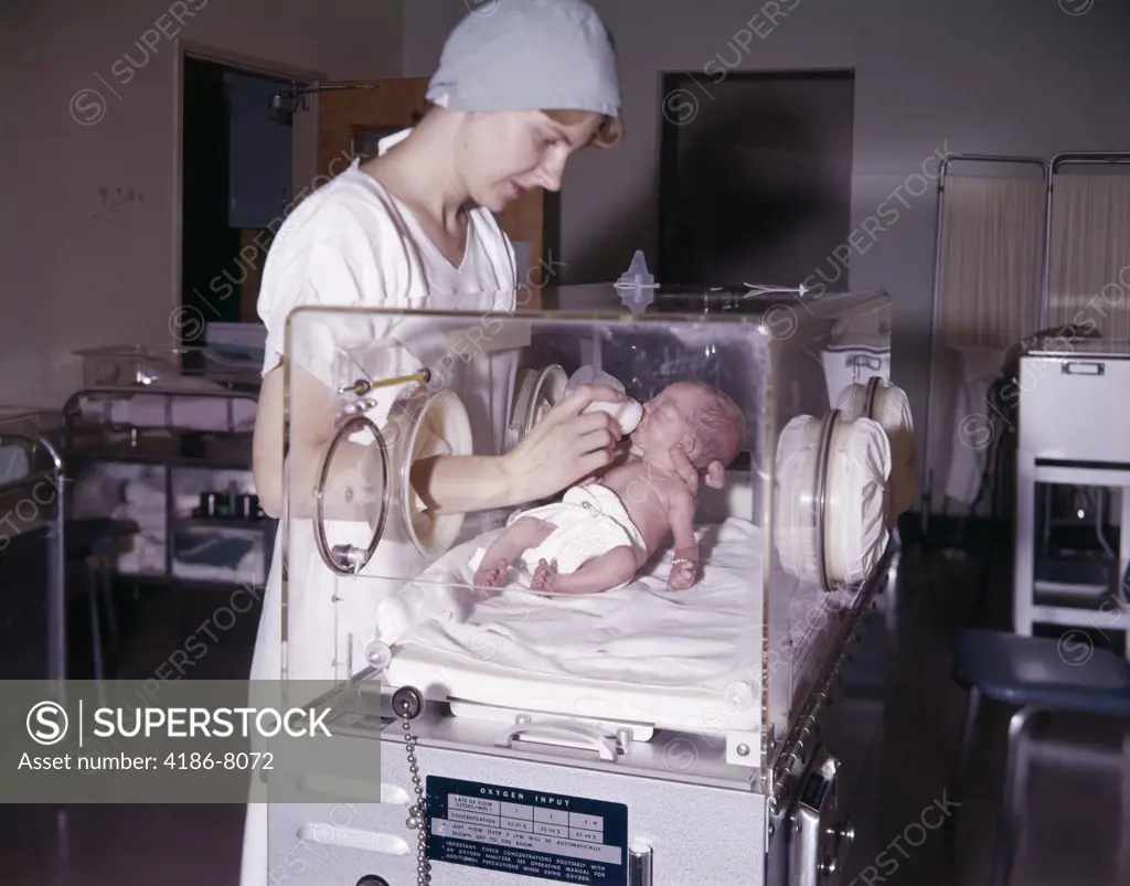 1960S Nurse Bottle Feeding Infant In Hospital Nursery Isolation Premature Intensive Care Woman