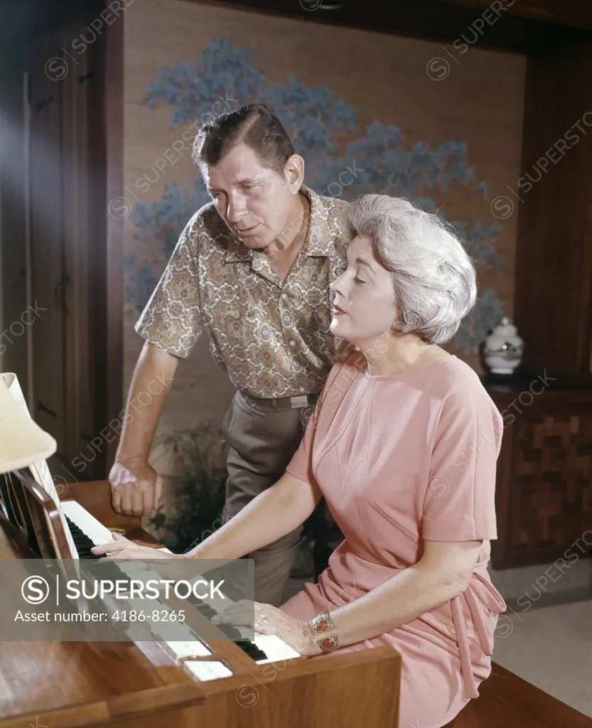 1960S Mature Couple Man And Woman Playing And Singing Together At Home Organ Keyboard Instrument