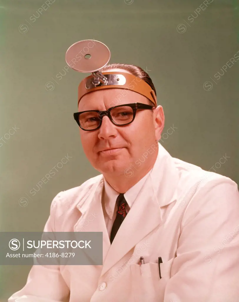 1950S 1960S Smiling Man Medical Doctor White Lab Coat Black Frame Eyeglasses Wearing Diagnostic Head Mirror On Forehead