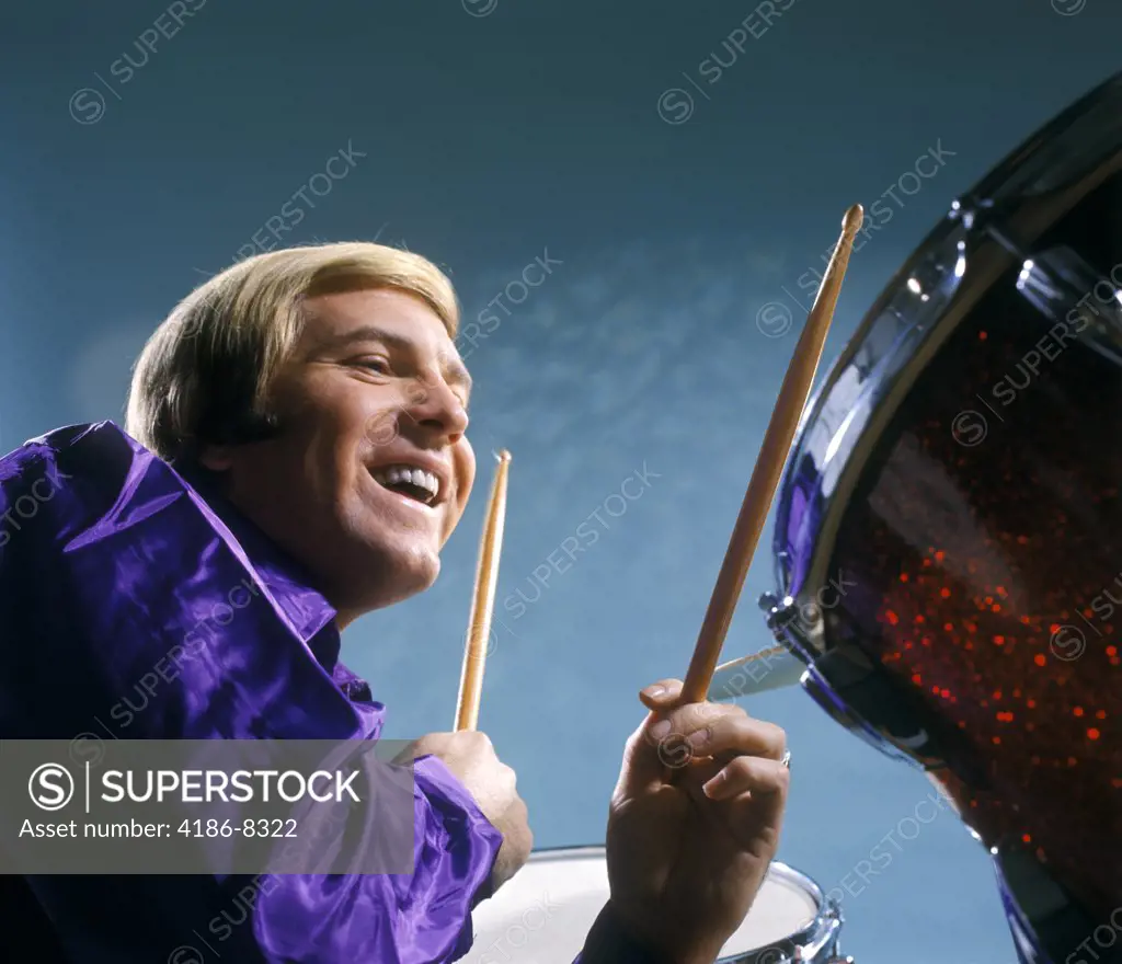 1970S Laughing Blond Man Musician Playing Drums Wearing Purple Shirt