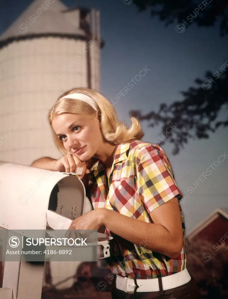 1960S Thoughtful Blond Woman Rural Delivery Mailbox Farm Background Putting Letter In Take Out Mail Box