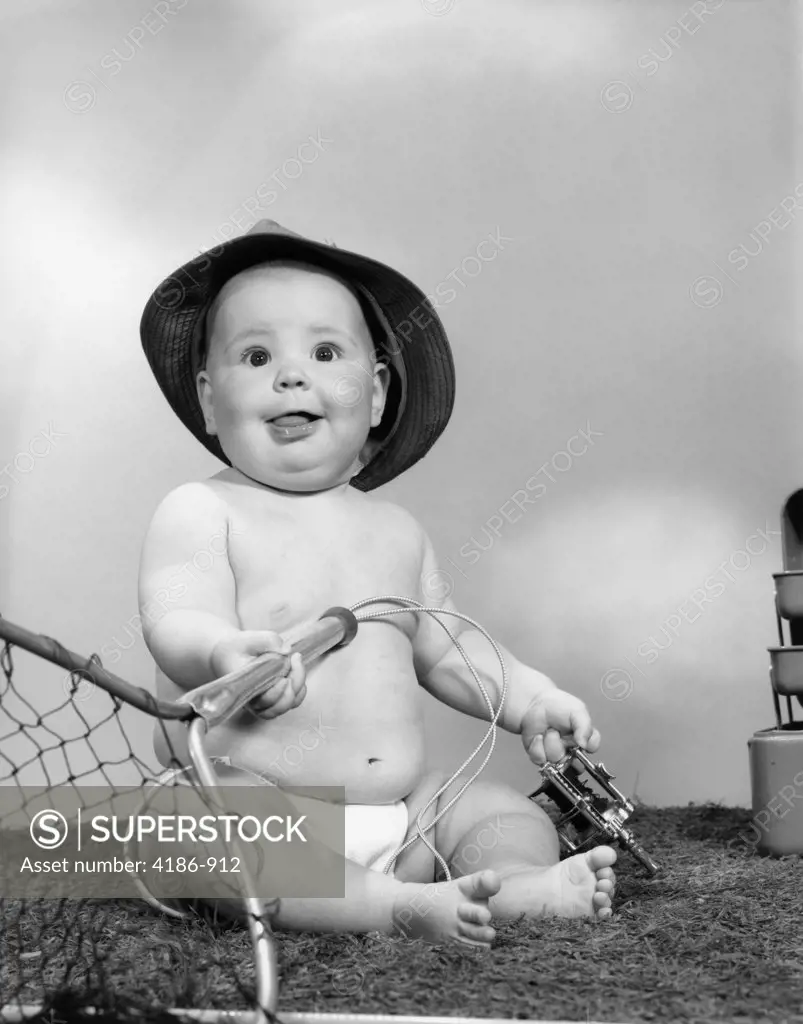 1960S Baby Girl Wearing Fishing Hat Holding Net And Reel Fishing Gear Indoor