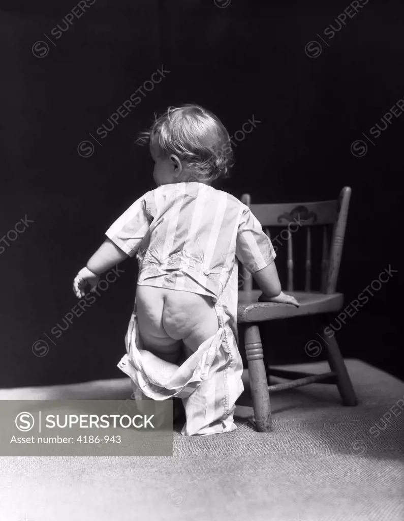 1940S Baby Wearing Drop Seat Pajamas Showing Bare Bottom Leaning On Chair