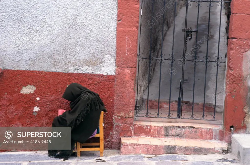 Mexico Person In Cloak Sitting By Iron Gate