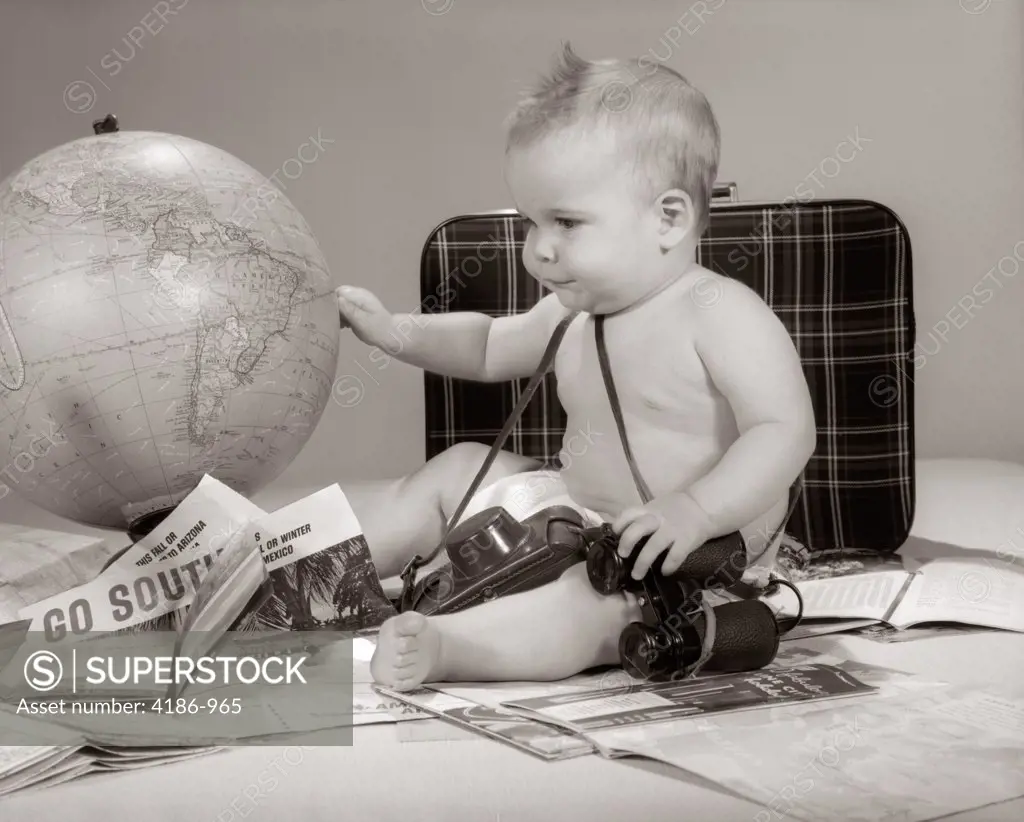 1960S Baby Seated Looking At Globe With Camera Binoculars Suitcase & Travel Brochures