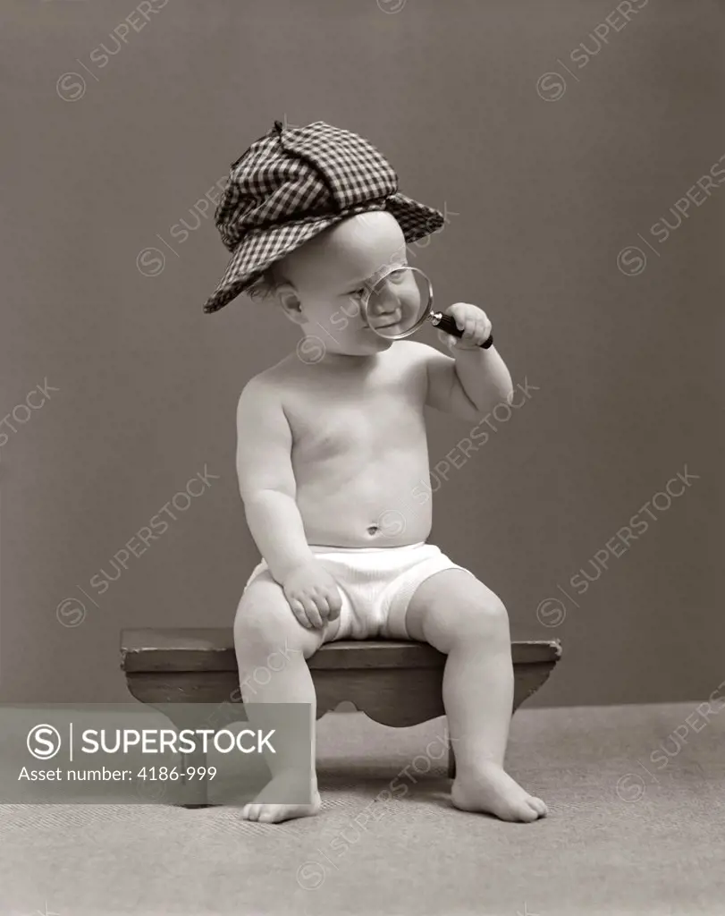 1940S Baby Sherlock Holmes In Diaper Sitting On Bench Wearing Deer Stalker Hat Looking Through Magnifying Glass