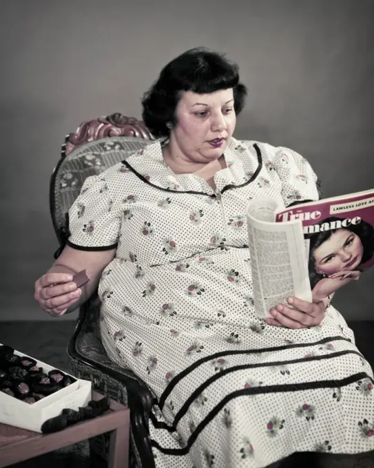 1950s OBESE OVERWEIGHT WOMAN SITTING EATING BOX OF CHOCOLATE CANDY READING MOVIE FAN MAGAZINE