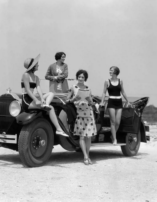 1920S 1930S Four Women In Dresses And Bathing Suits Gathered Around Convertible Touring Car At Seashore Beach