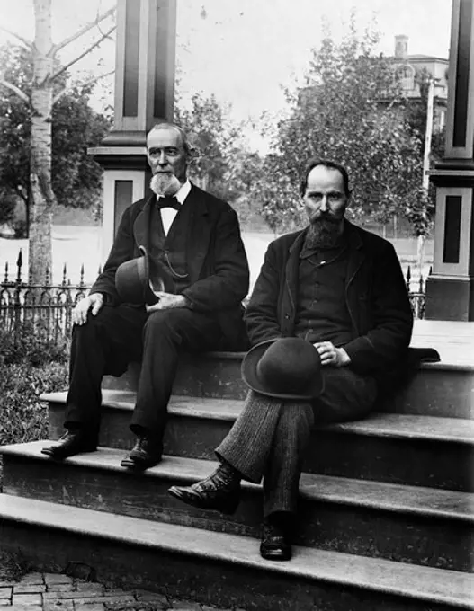 1890S Turn Of The Century Two Bearded Men Father And Son In Suits Holding Bowler Hats Sitting On Stairs In Front Of House