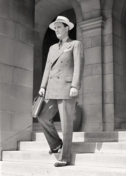 1940s MAN WALKING DOWN STEPS HOLDING BRIEFCASE WEARING GLEN PLAID DOUBLE BREASTED SUIT SPECTATOR WINGTIP SHOES SUMMER WEIGHT HAT