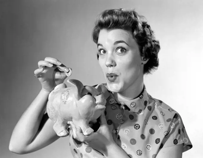 1950S Woman Dropping Money In Piggy Bank