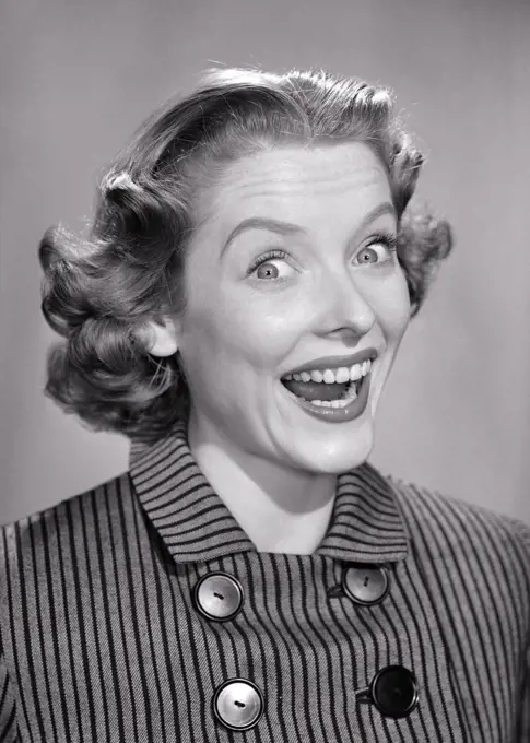 1950s PORTRAIT OF EXCITED HAPPY WOMAN WEARING STRIPED BUTTONED TOP WIDE SMILE BUG-EYES FLIP HAIRSTYLE LOOKING AT CAMERA