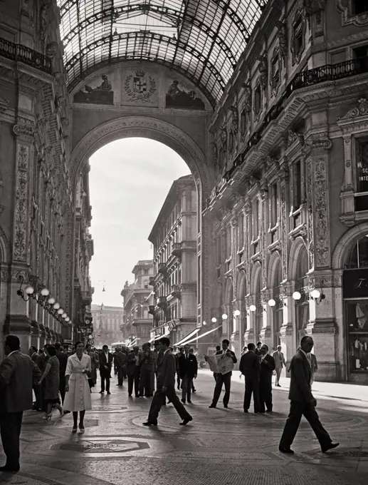 1920s PEOPLE MEN AND WOMEN PEDESTRIANS SHOPPERS WALKING BENEATH GALLERIA VITTORIO EMMANUEL II 1877 GLASS ARCHWAY MILAN ITALY
