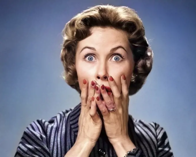 1950s PORTRAIT OF WOMAN IN STRIPED DRESS HANDS TO MOUTH WITH SHOCKED SURPRISED ALARMED EXPRESSION LOOKING AT CAMERA