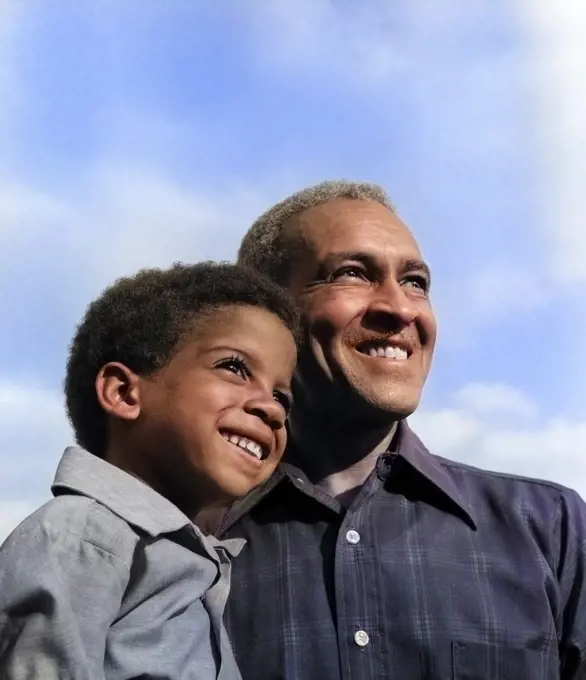 1970s SMILING AFRICAN AMERICAN BOY & GRANDFATHER WITH ARMS AROUND EACH OTHER LOOKING OFF INTO DISTANCE