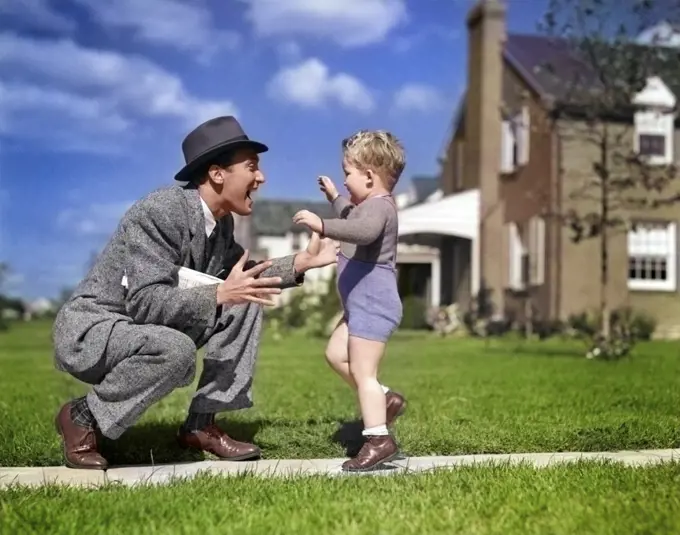 1940s FATHER GREETING SON RUNNING TOWARDS HIM ON SIDEWALK