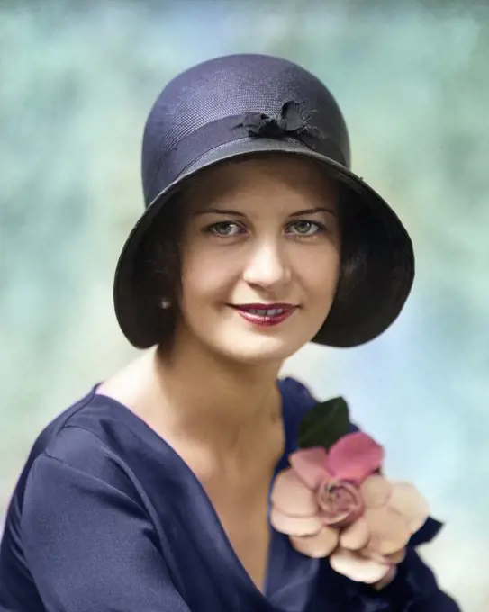 1930s HEAD AND SHOULDERS PORTRAIT OF PLEASANT ATTRACTIVE SMILING WOMAN LOOKING AT CAMERA WEARING CLOCHE HAT AND FLOWER ON BLOUSE