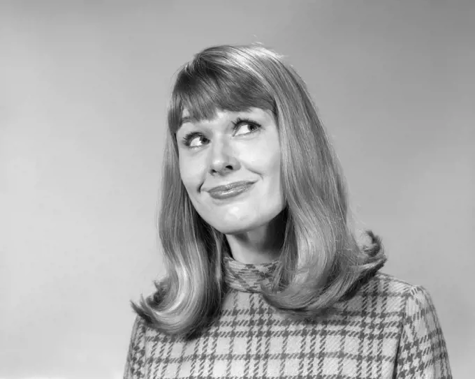 1960s WOMAN WITH LONG HAIR FLIP STYLE WITH BANGS LOOKING UP WITH AMUSED SMILE FACIAL EXPRESSION 