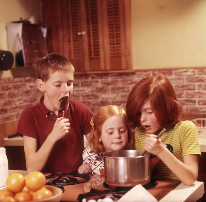 1970s 3 KIDS GIRLS BOY MAKING FUDGE BOY LICKING SPOON GIRL STIRRING PAN ON STOVE
