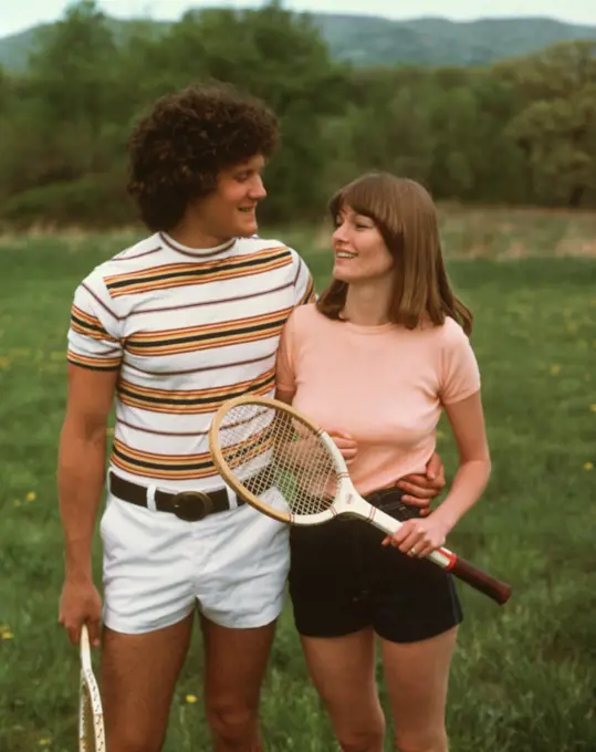 1970s 1980s COUPLE WEARING TENNIS SHORTS HOLDING RACKETS