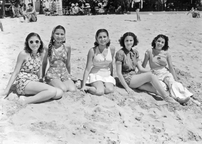 1930s 1940s FIVE SMILING WOMEN IN BEACH CLOTHES SITTING IN THE SAND LOOKING AT CAMERA LA PLAYA HAVANA CUBA