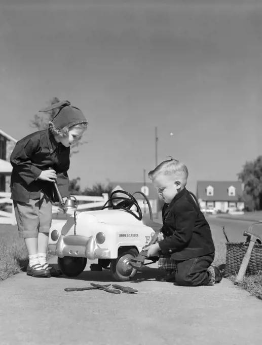 1930s TWO CHILDREN BOY AND A GIRL WORKING FIXING SERVICING A TOY PEDDLE CAR AUTOMOBILE