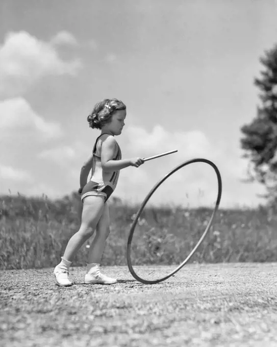 1930s GIRL OUTDOORS ROLLING A HOOP PLAYING HOOP AND STICK GAME 