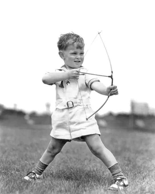 1930s BOY OUTDOORS AIMING TOY BOW AND ARROW ARCHERY