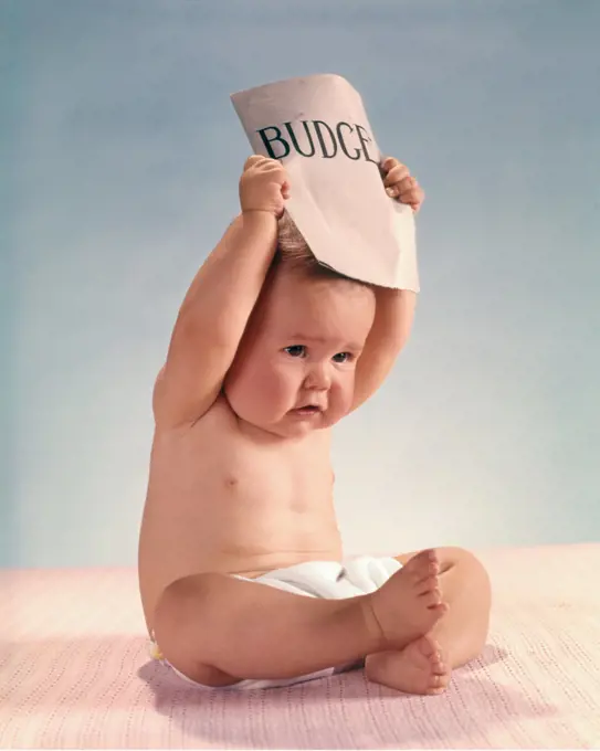 1960s DISTRESSED FRUSTRATED BABY ACTOR SITTING HOLDING BUDGET DOCUMENT OVER HEAD