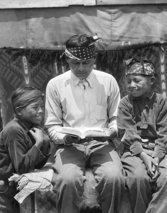 1930s NATIVE AMERICAN INDIAN NAVAJO MAN FATHER READING BOOK TO TWO SMILING BOYS SONS