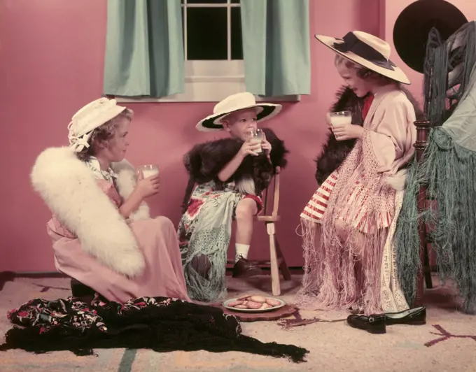 1950s THREE LITTLE GIRLS DRINKING MILK PLAYING ADULT DRESS UP IN OLD CLOTHES AND HATS