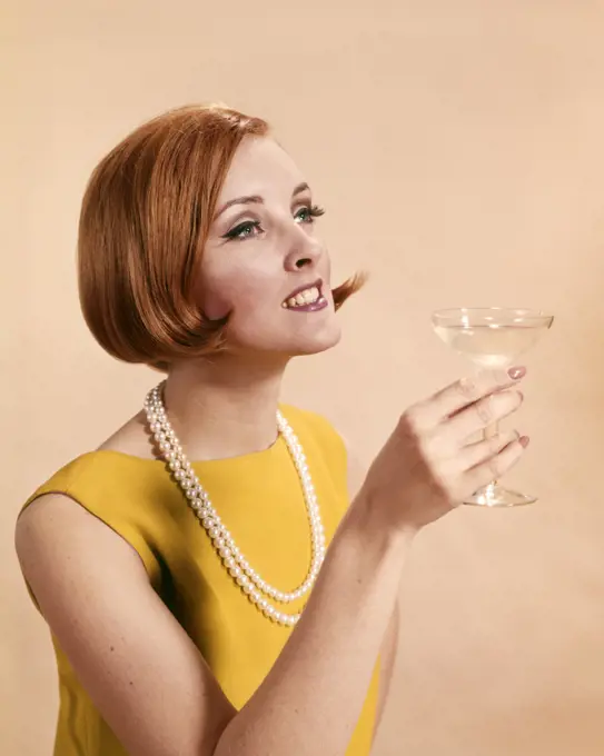 1960s FASHIONABLE RED HEADED WOMAN TOASTING HOLDING GLASS OF CHAMPAGNE 