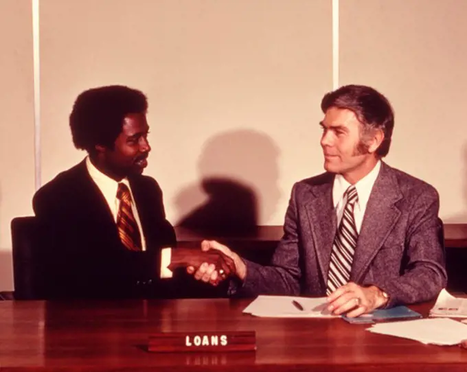 1970S African American Man Shaking Hands With Bank Loan Officer