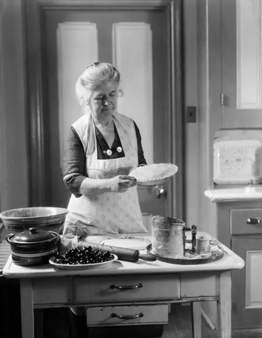 1920S 1930S Woman Grandmother Wearing Apron Crimping Crust Making A Cherry Pie
