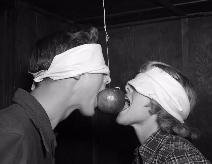 1950S Blindfolded Teenage Couple Boy Girl Trying To Eat An Apple Hanging On A String