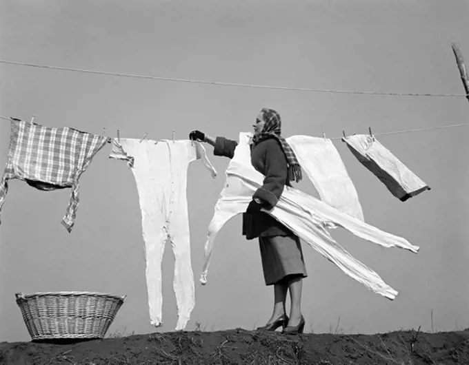 1950S Housewife Removing Frozen Long Johns From Clothesline