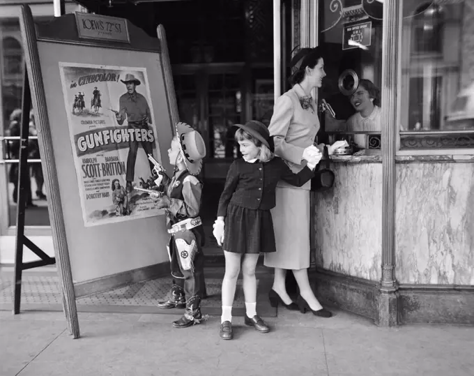 1950S Mother 2 Children Buying Tickets To Movie Matinee Boy Wearing Cowboy Costume 