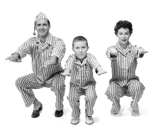 1950S Family Of 3 In Pajamas Doing Knee Bends Facing Camera