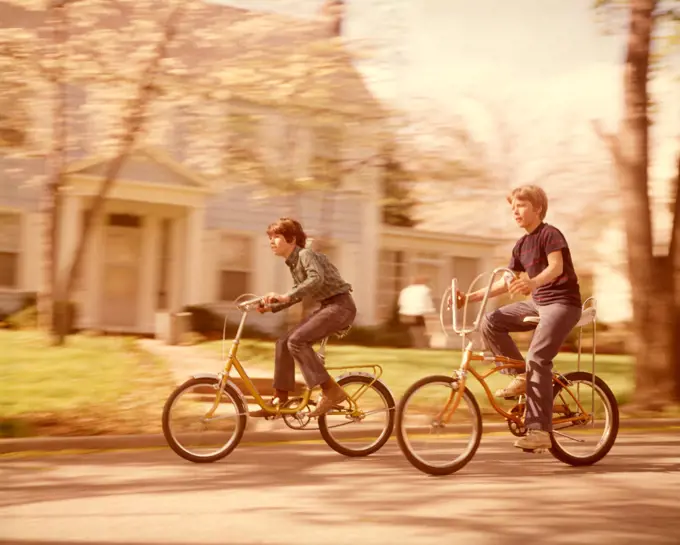1970S Boys Riding Bikes  On Suburban Street Springtime