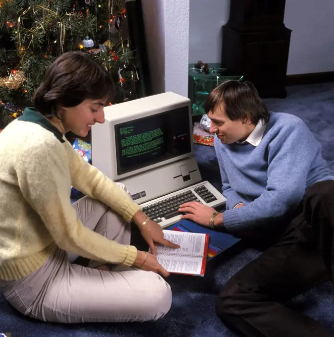 1980S Couple By Christmas Tree Reading Instructions For An Apple Iii Computer  
