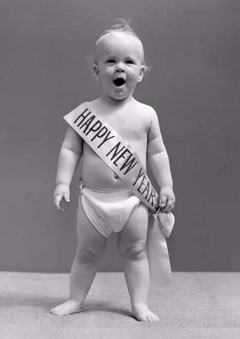 1940S Baby Standing In Diaper Yawning Wearing Happy New Year Sash