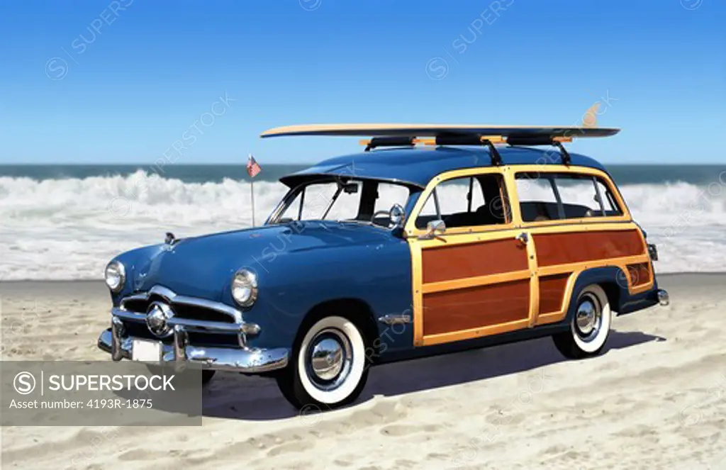 woodie car on the beach with surfboard and blue sky