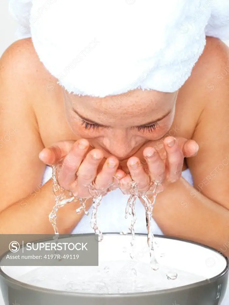 Closeup of a young woman washing her face with water