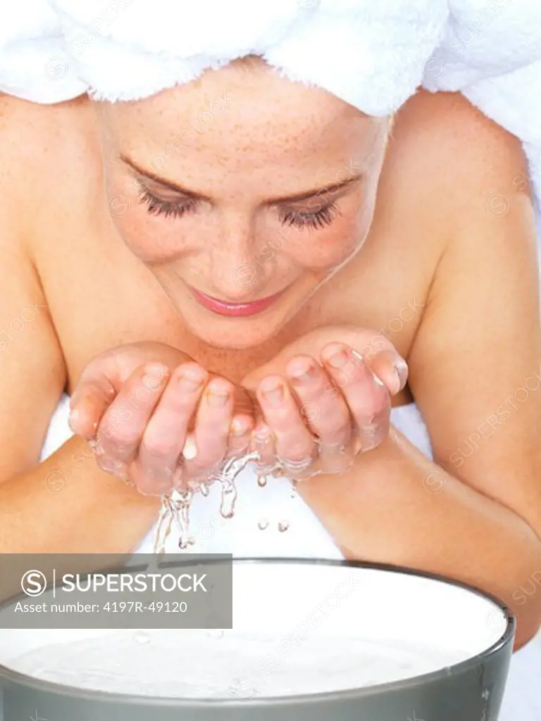 Closeup of a pretty woman washing her face with water
