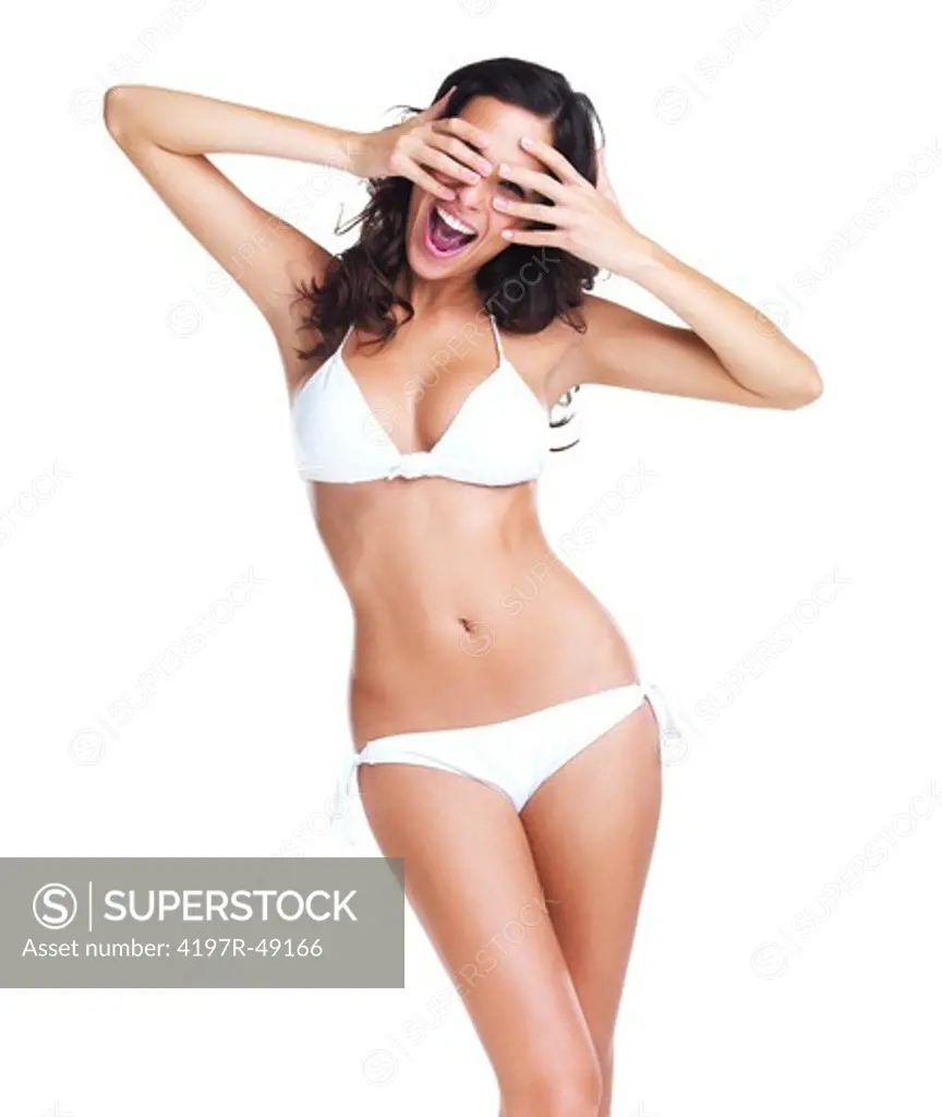 Gorgeous young woman in a white bikini being expressive and covering her face while isolated on white