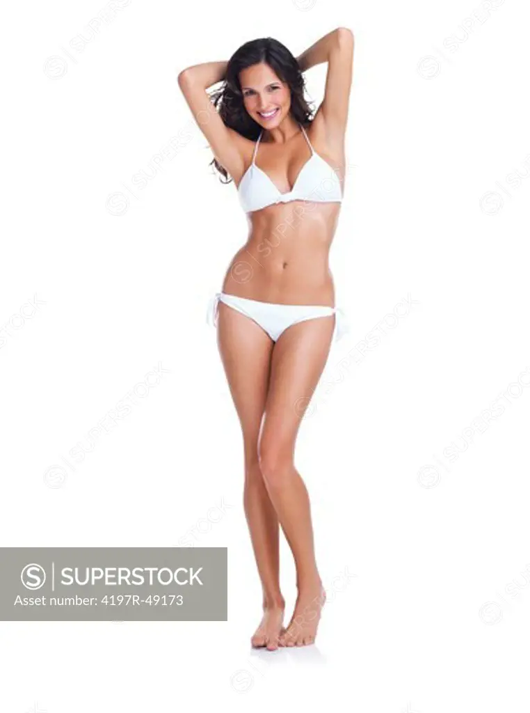 Curvaceous and beautiful young woman in a white bikini standing isolated on white