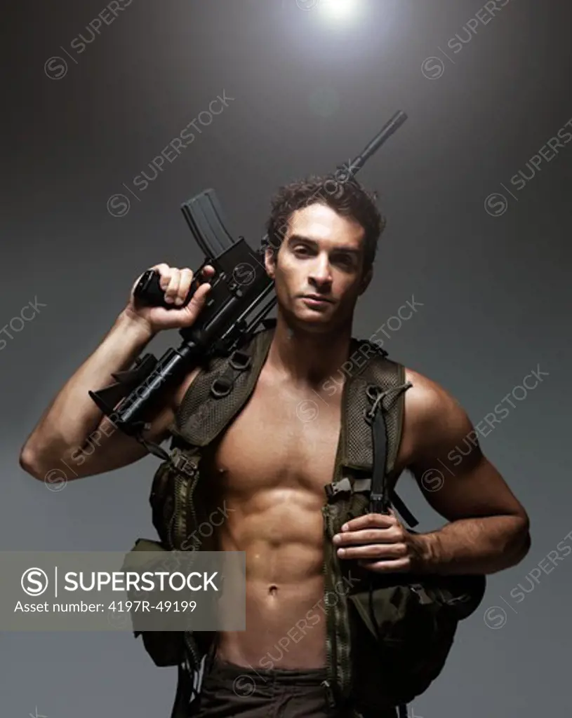 Attractive soldier looking at the camera while holding his M16 rifle over his shoulder